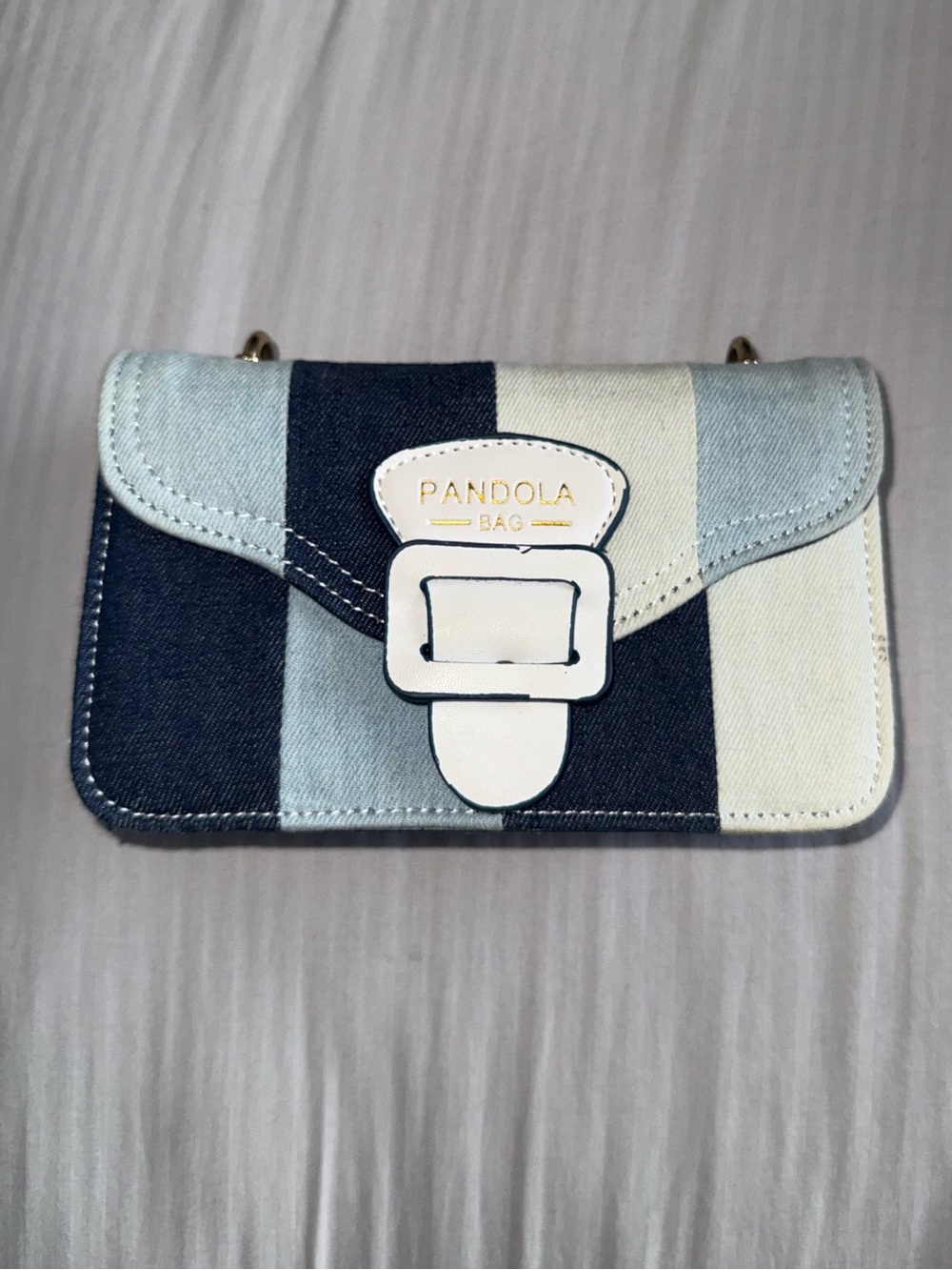 Blue and white striped shoulder bag with a chic buckle detail.